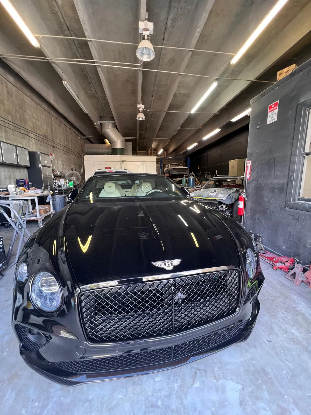 Black Bentley Continental GT parked inside the Craft Collision body shop