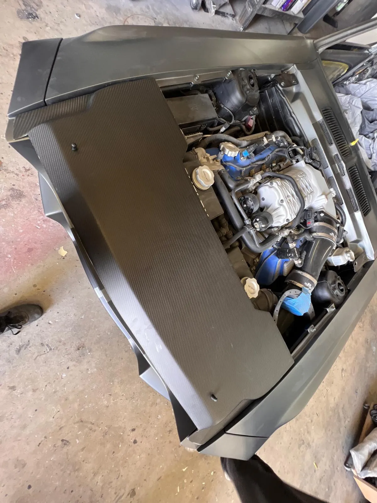 Carbon fiber hood raised over the engine bay of a custom build during test fitting