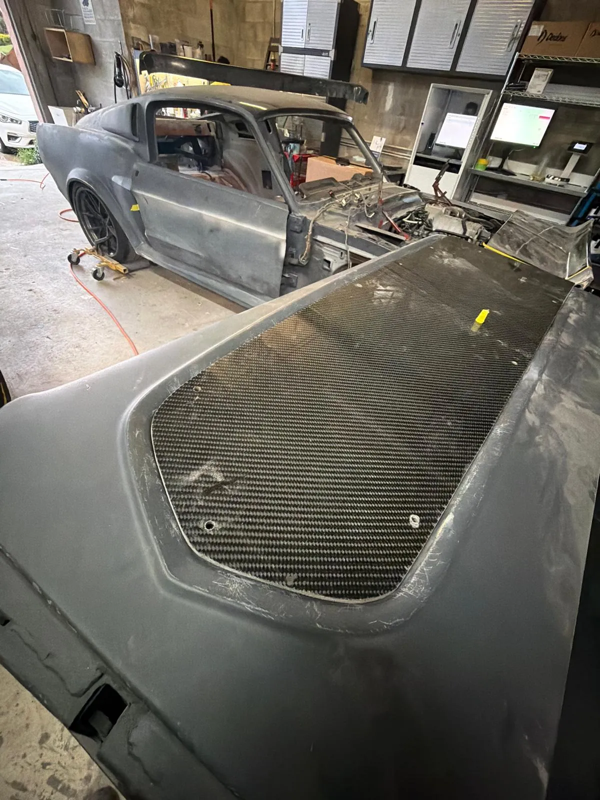 Carbon fiber panel fitted into the rear bodywork of a Mustang fastback build