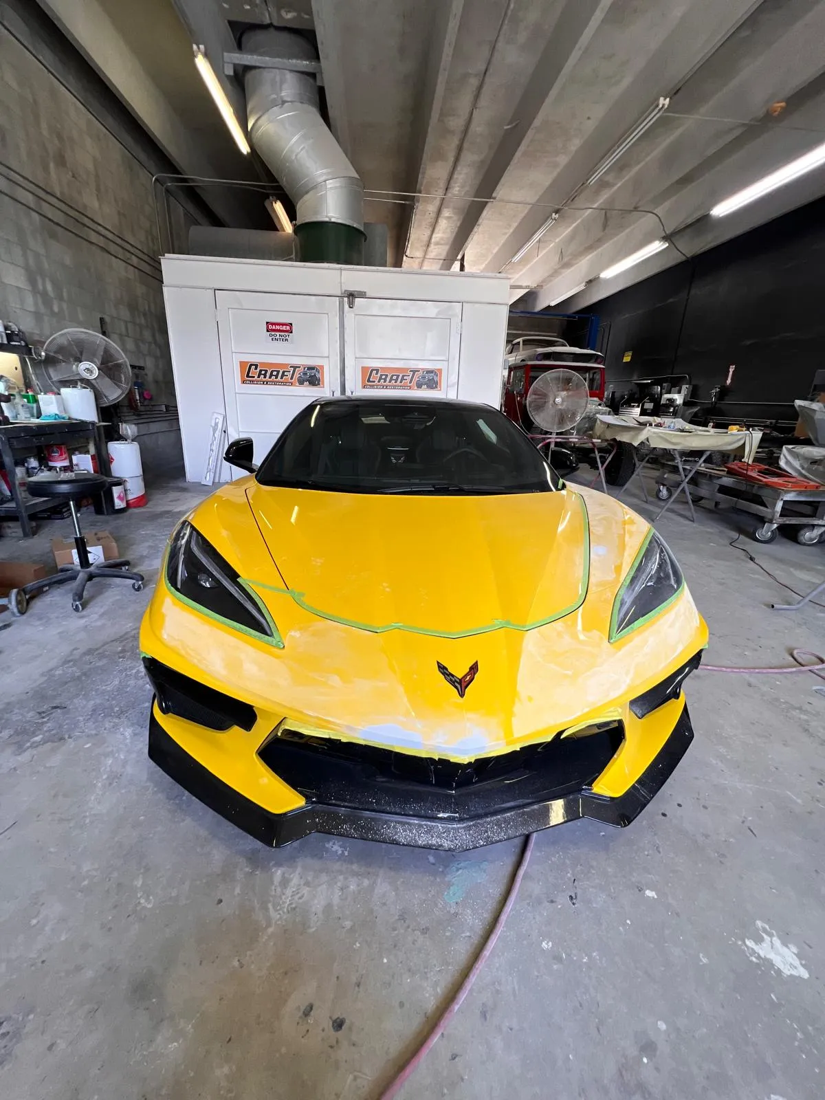 Front bumper of a yellow Corvette C8 refinished and refitted in the shop