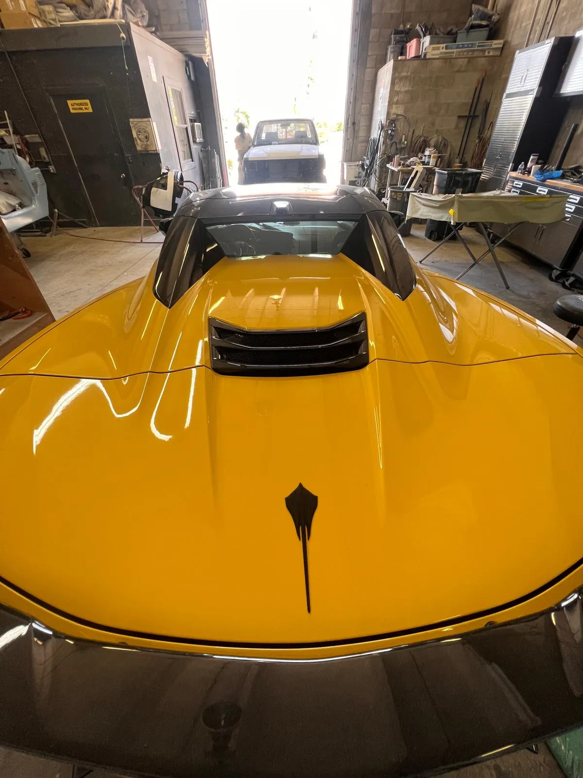 Close-up of the glossy yellow hood of a Corvette C8 after refinishing