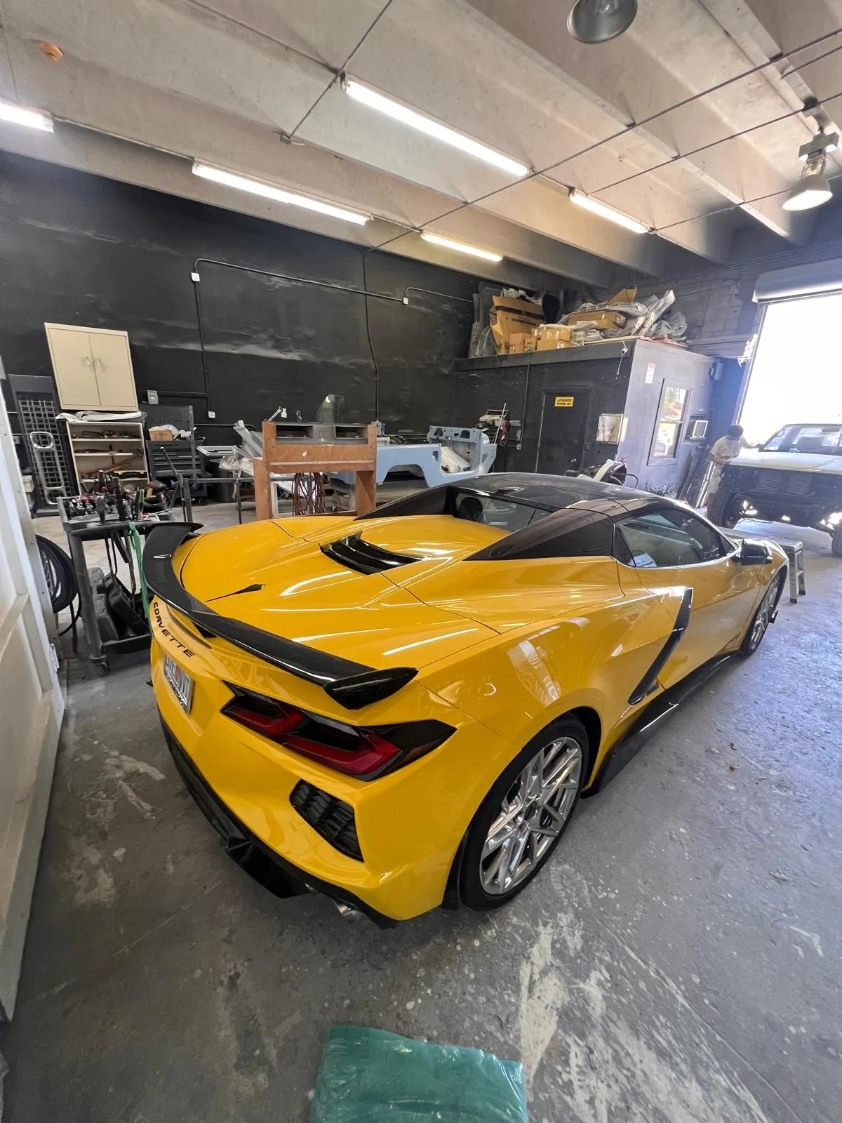 Rear three-quarter view of a yellow Corvette C8 after paint work at Craft Collision