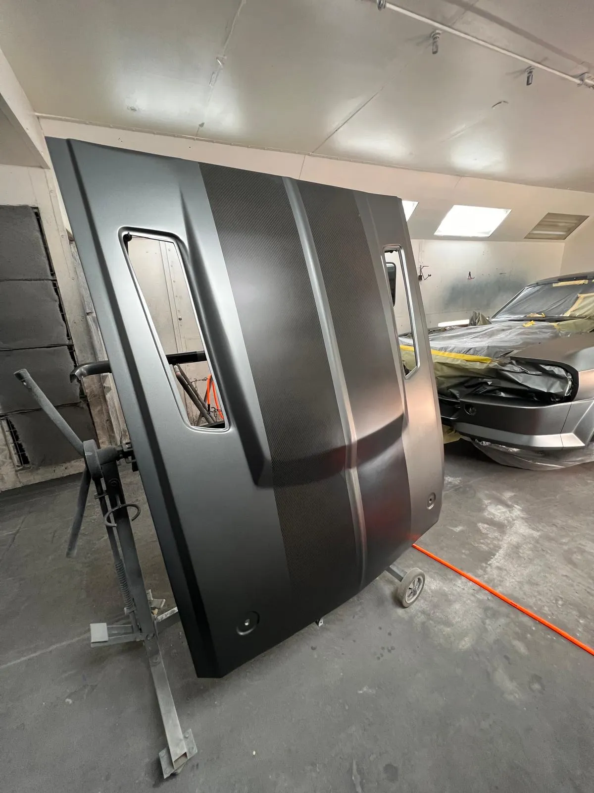 Freshly painted matte grey doors and panels on a stand at Craft Collision
