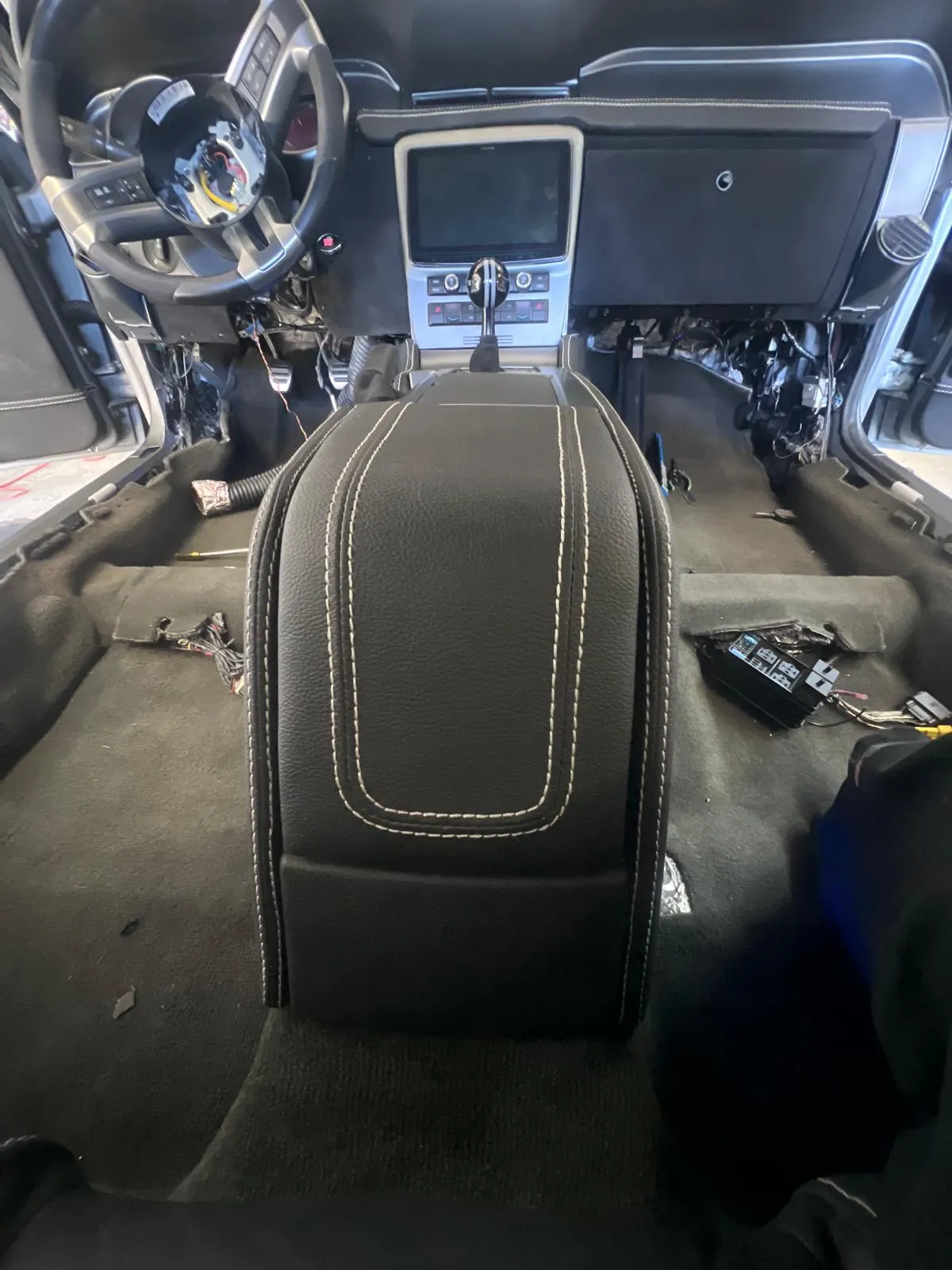 Custom stitched center console and dashboard inside a Mustang fastback build