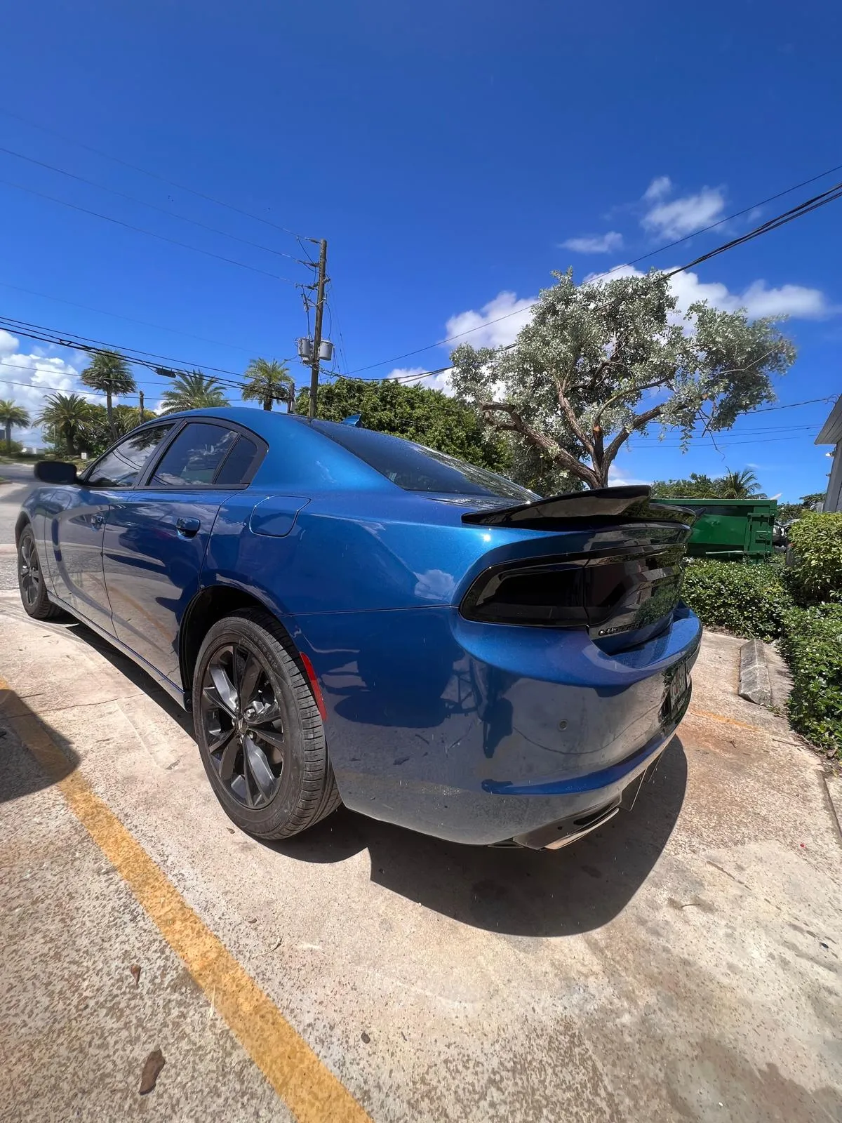 Blue Dodge Charger parked outside the shop after rear-end repair and paint