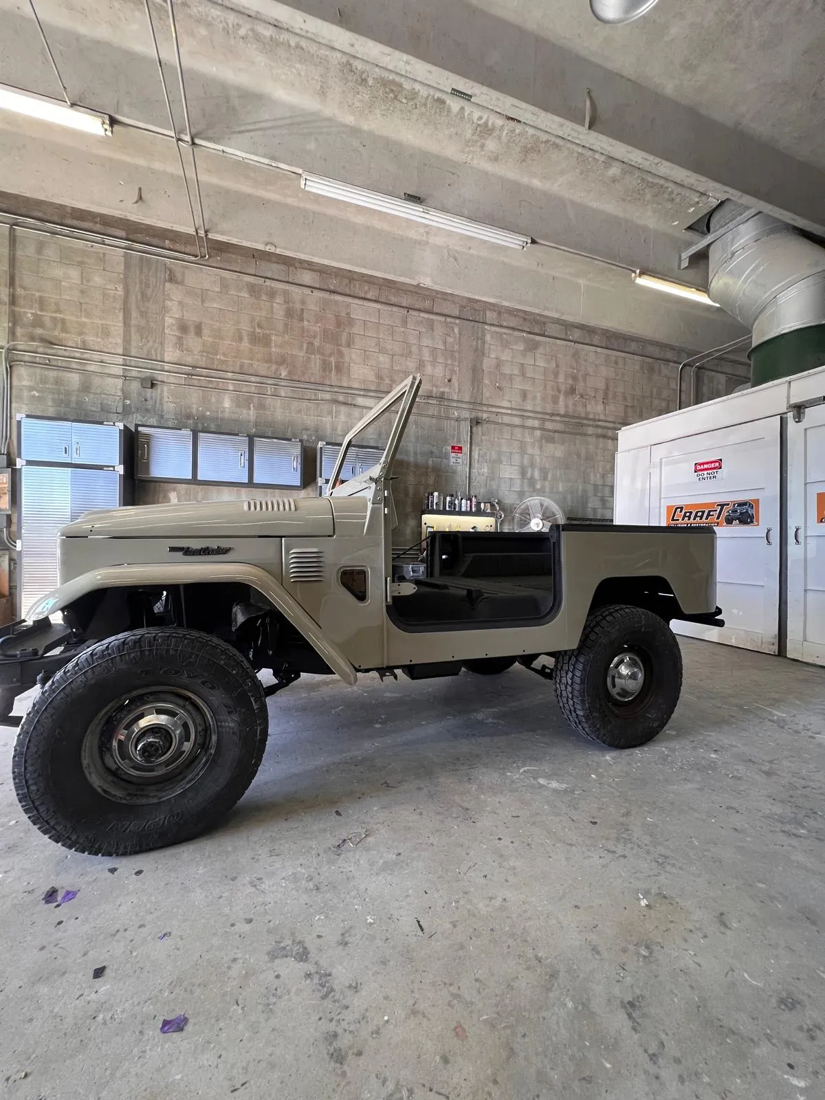 Restored Toyota FJ40 body reunited with the frame in the Craft Collision shop