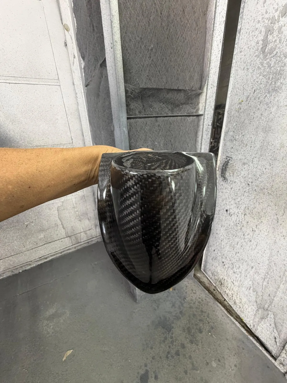 Hand-made carbon fiber mirror housing held up in the Craft Collision shop