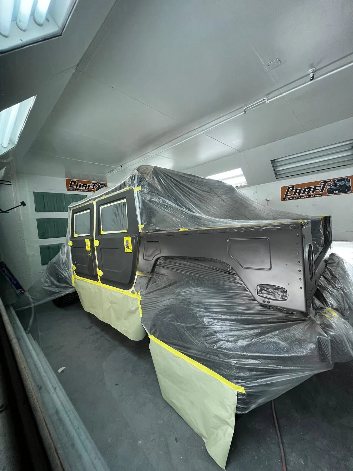 Hummer H1 body panels masked and covered inside the paint booth