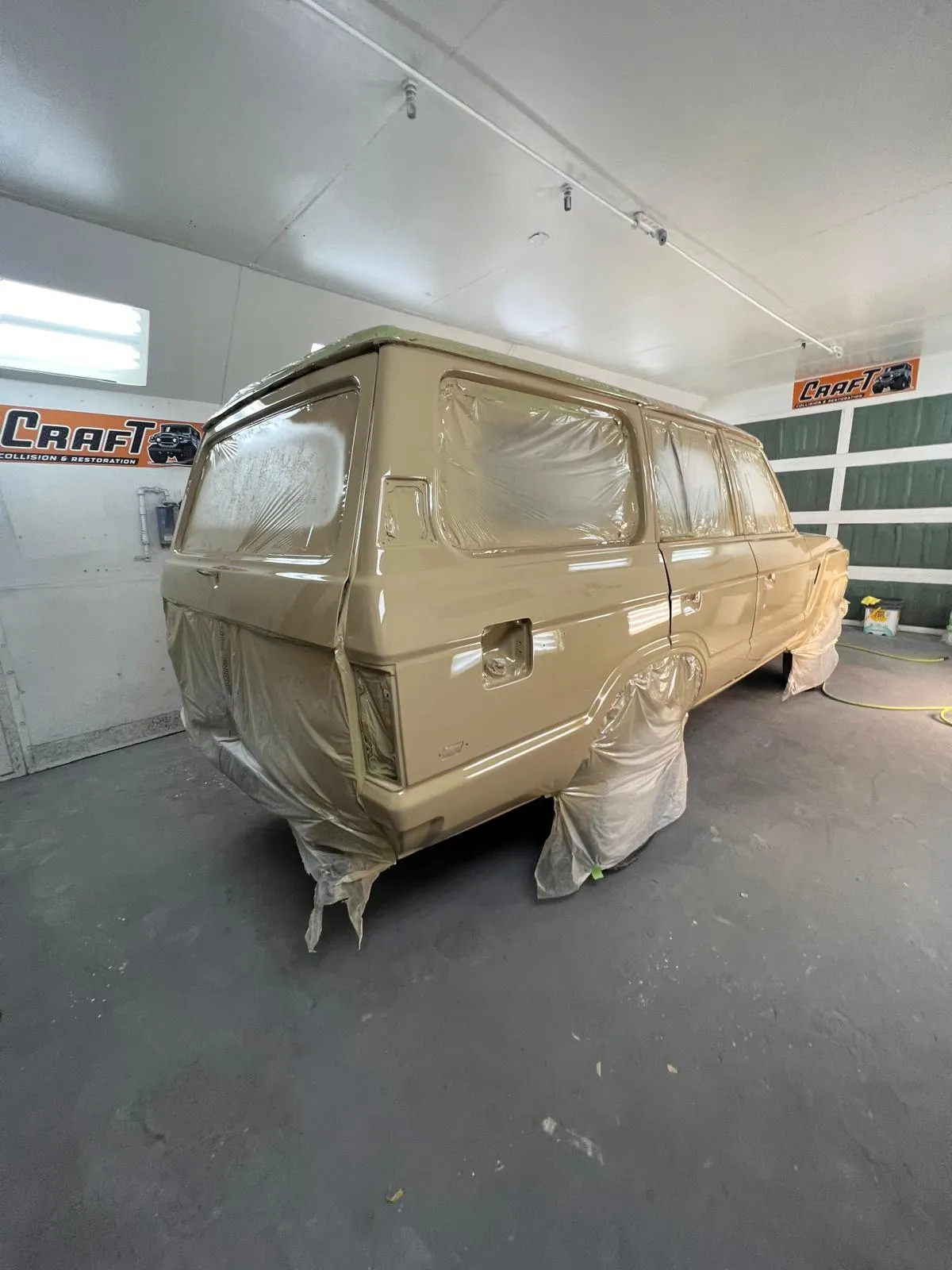 Toyota Land Cruiser FJ60 masked and covered inside the paint booth