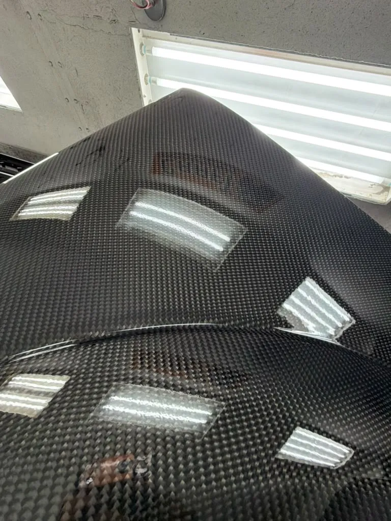 Close-up of a repaired carbon fiber panel after refinishing at Craft Collision