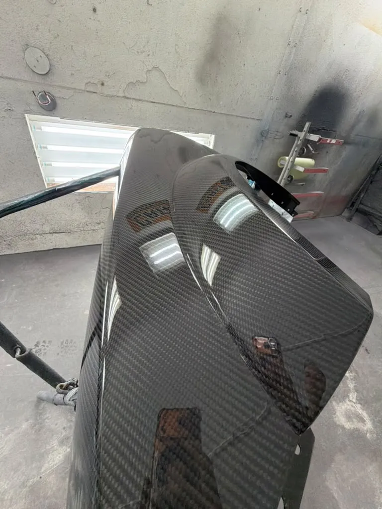 Repaired carbon fiber panel on a stand in the Craft Collision shop