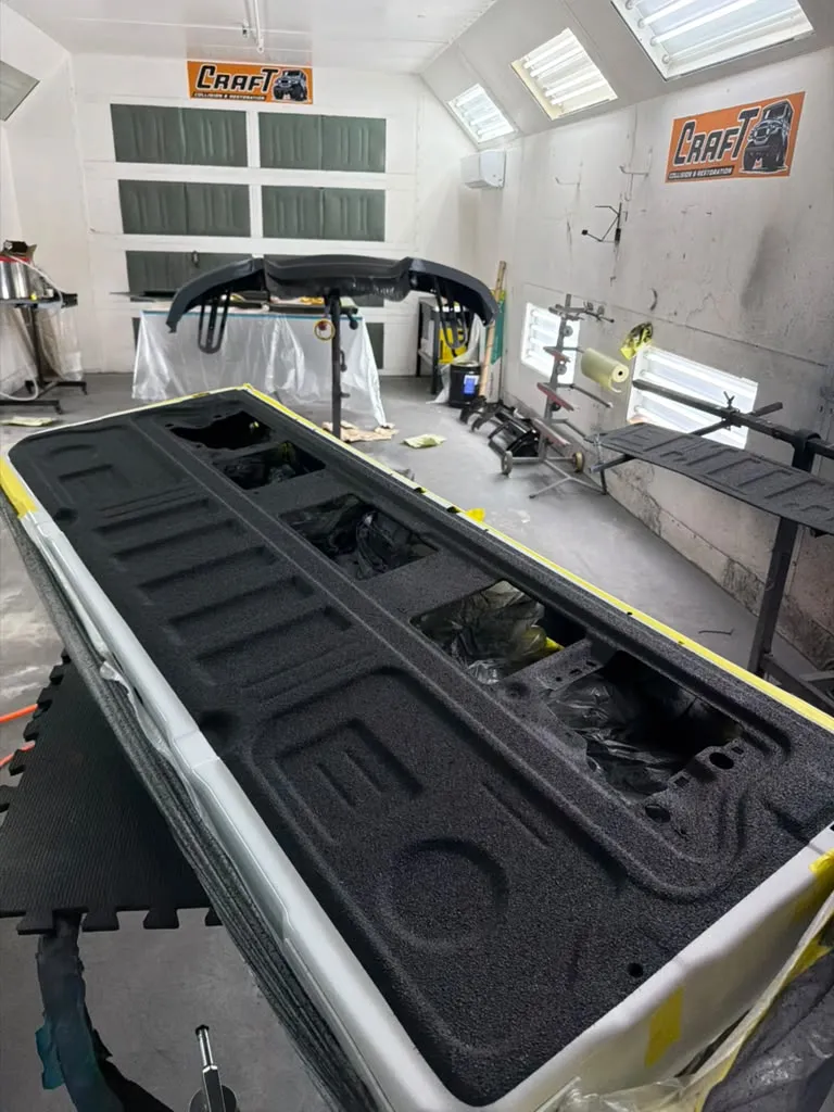 Pickup truck bed with a fresh black spray-in bedliner applied at Craft Collision in Lake Worth Beach